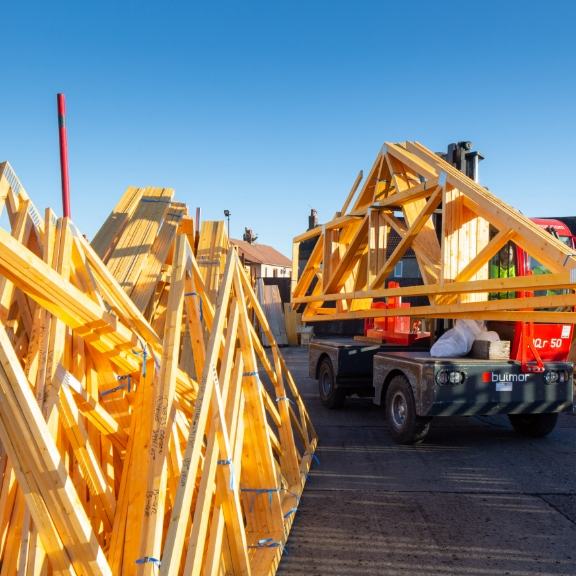 A telehandler stacking roof trusses made by Donaldson Direct